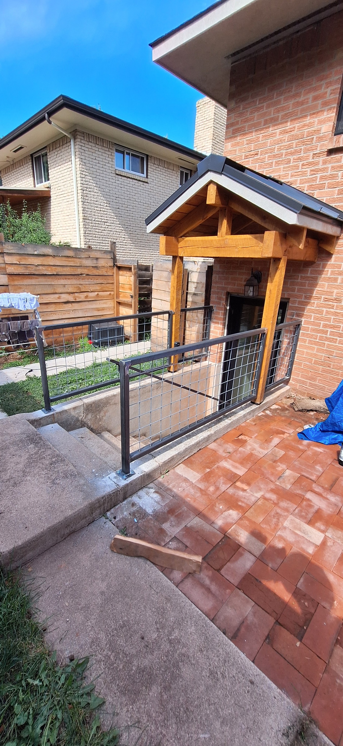 Timber frame entry porch with metal railing